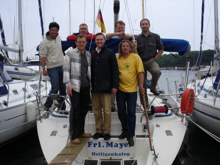 7 people at the stern of a sailboat
