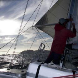 A man hoists the sails of a boat